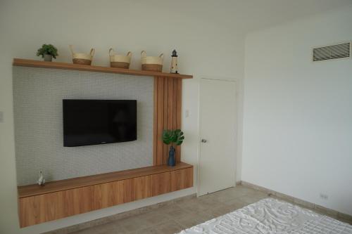 a living room with a flat screen tv on a wall at Hotel Colon Salinas 2 bedroom Oceanview apartment in Salinas