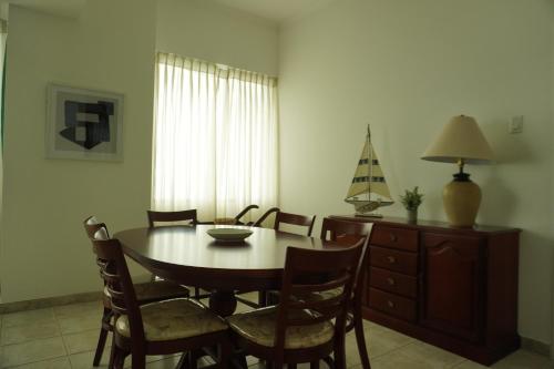 a dining room with a wooden table and chairs at Hotel Colon Salinas 2 bedroom Oceanview apartment in Salinas