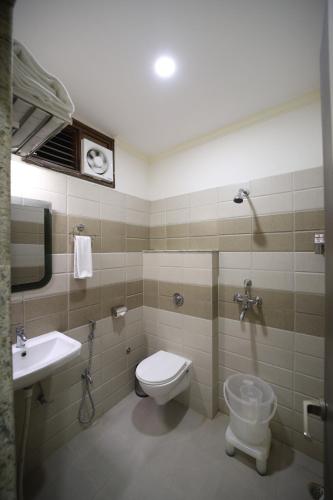 a bathroom with a toilet and a sink at Hari Haran Prestige in Varanasi