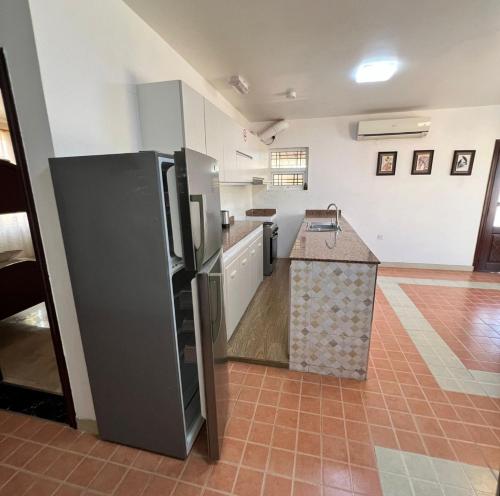 a large kitchen with a refrigerator and a counter at شاليهات الكرامة in Al Muladdah