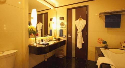 a bathroom with a white robe hanging on a door at Changchun Zhuozhan Days Hotel in Changchun