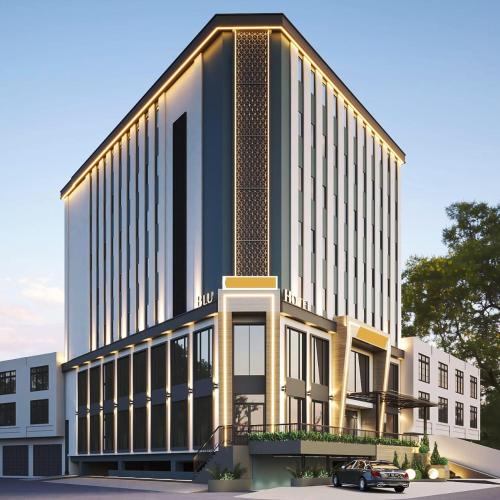 メダンにあるMBS HOTEL Medanの建物の前に車が駐車されている