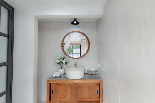 a bathroom with a sink and a mirror at Ubud Suarga Private Pool Villa in Ubud