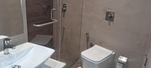 a bathroom with a white toilet and a sink at Shine Hospitality Boutique Hotel in Mumbai
