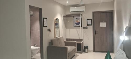 a hospital room with a chair and a door at Shine Hospitality Boutique Hotel in Mumbai