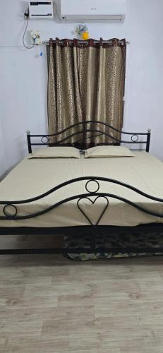 a bed with a black bed frame with a curtain at Kasi's Home Stay A6 in Chennai