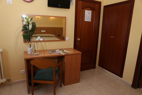 Habitación con escritorio, espejo y cama. en Hotel Europa de Figueres, en Figueres