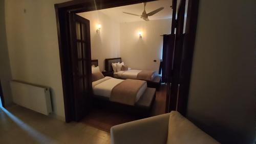 a reflection of a bedroom with two beds in a mirror at CHK INN by ChenOne in Lahore