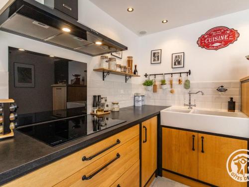 une cuisine avec un évier et un plan de travail dans l'établissement Gîte de Charme en Campagne - Confort & Luxe - FR-1-622-110, à Chazé-sur-Argos