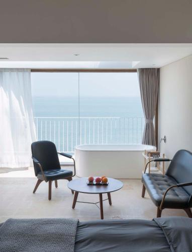 a living room with a couch and two chairs and a table at 朴宿栖澜海居崂山风景区店 in Qingdao