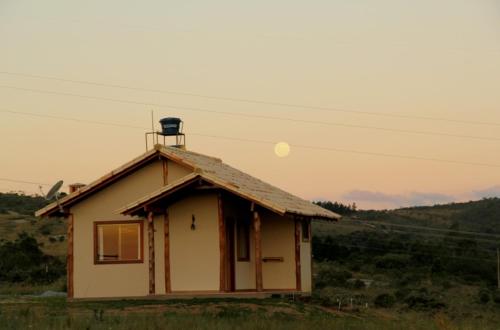 a small house in the middle of a field at Pousada Gaya in Carrancas