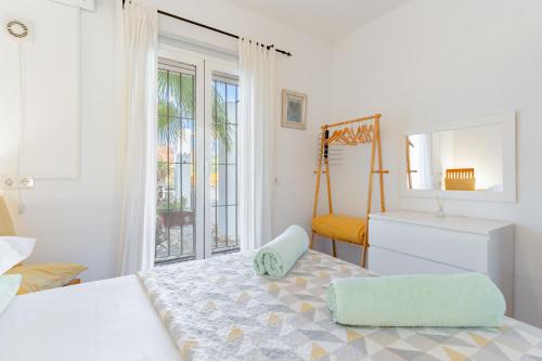 a white bedroom with a bed and a window at Finca Lavinia in Alhaurín el Grande