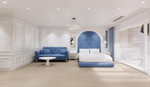 a bedroom with a bed and two blue chairs at The Siena PRIMO in Seogwipo