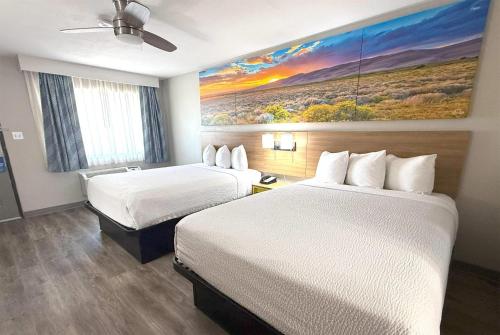 a hotel room with two beds and a painting on the wall at Days Inn by Wyndham Yuma in Yuma