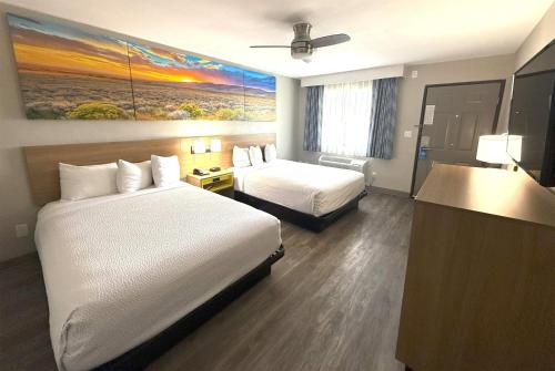 a hotel room with two beds and a painting on the wall at Days Inn by Wyndham Yuma in Yuma