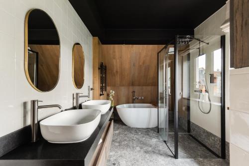a bathroom with two sinks and two mirrors at IJG Imperial Apartamenty Krupówki in Zakopane