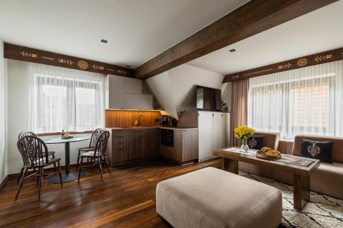 a kitchen and living room with a table and a couch at IJG Imperial Apartamenty Krupówki in Zakopane