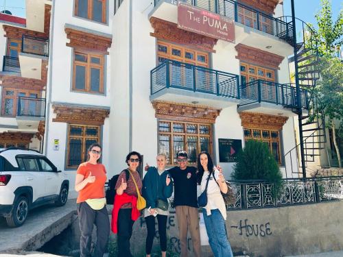 a group of people standing in front of a building at The Puma house in Leh