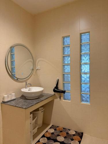 een badkamer met een wastafel, een spiegel en een raam bij Tropical 1 Bedroom Pool House In Central Location in Hua Hin