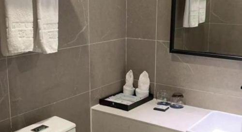a bathroom with a sink and a toilet and a mirror at H Life Hotel Nanshan Branch in Shenzhen