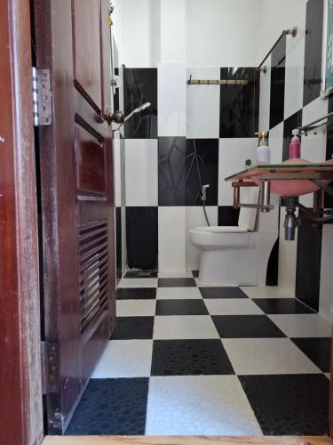 a bathroom with a black and white checkered floor at Realkhom Homestay in Siem Reap