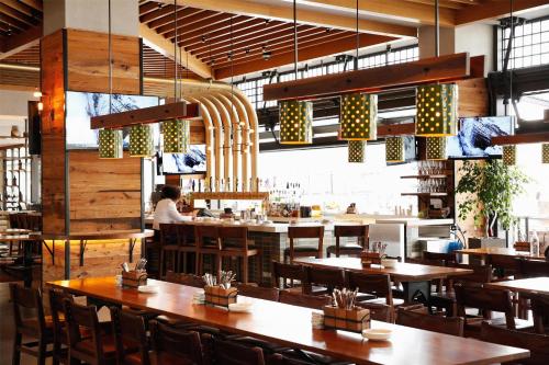 a restaurant with wooden tables and chairs and a person in the background at Hyatt Regency Tysons Corner Center in Tysons Corner