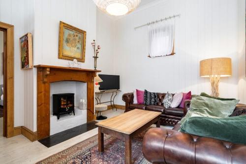 a living room with a couch and a fireplace at Coachman's Cottage Glenelg in Glenelg