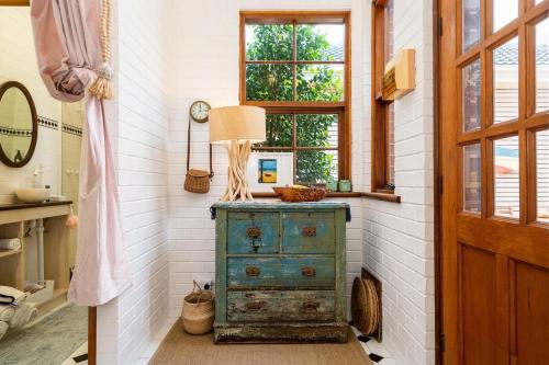 Cette chambre comprend une commode avec une lampe. dans l'établissement Coachman's Cottage Glenelg, à Glenelg