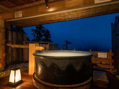 a large bath tub sitting on a deck with a candle at Shirayunoyado Yamadaya Hakone Gora in Hakone