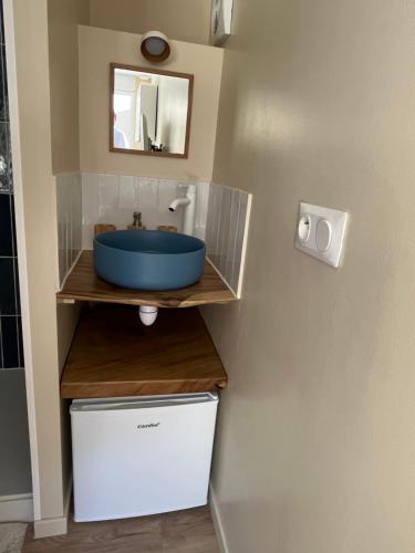 a bathroom with a blue sink on a shelf at Chambre et salle de bain dans dépendance in Marseille