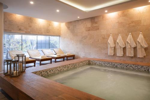 a bathroom with a large tub in a room with chairs at Dazzler by Wyndham Montevideo in Montevideo