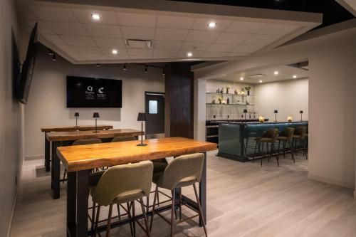 a restaurant with a table and chairs and a bar at Comfort Suites Kingston Central in Kingston