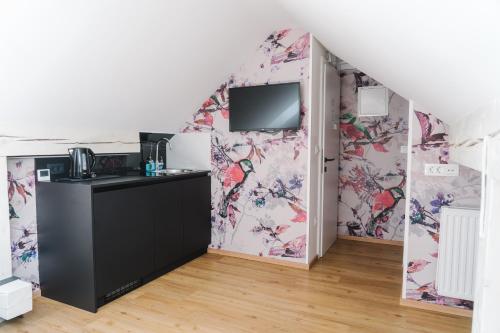a room with a kitchen with floral wallpaper at Lilija apartments in Trzin