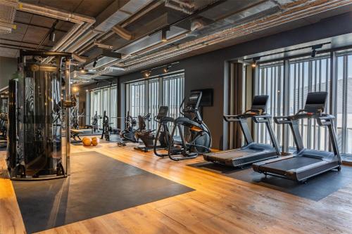 a gym with several treadmills and exercise bikes at Me and All Hotel ulm, by Hyatt in Ulm