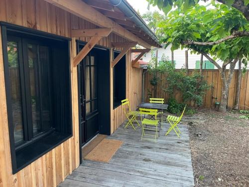 une terrasse en bois avec des chaises et une table. dans l'établissement La cabane de lesquirey, à La Celle-sous-Gouzon