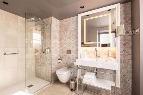 a bathroom with a toilet and a sink and a shower at Dolce by Wyndham Versailles - Domaine du Montcel in Jouy-en-Josas