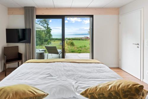 a bedroom with a large bed and a sliding glass door at Lodge Glardons in Marin