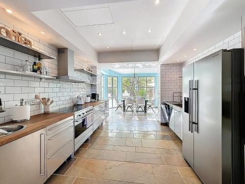 une grande cuisine avec des appareils électroménagers blancs et une salle à manger dans l'établissement 126m2 - maison plage, 3 chambres, 3 salles de bain, à Cannes