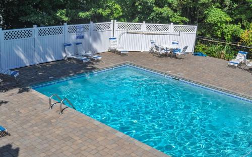 a swimming pool with blue water and chairs and a fence at Among The Clouds 2240 in Gatlinburg