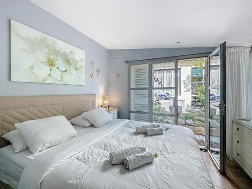 une chambre avec un grand lit avec deux oreillers dessus dans l'établissement 126m2 - maison plage, 3 chambres, 3 salles de bain, à Cannes