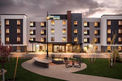 a hotel building with a courtyard with tables and chairs at Everhome Suites Bozeman in Bozeman
