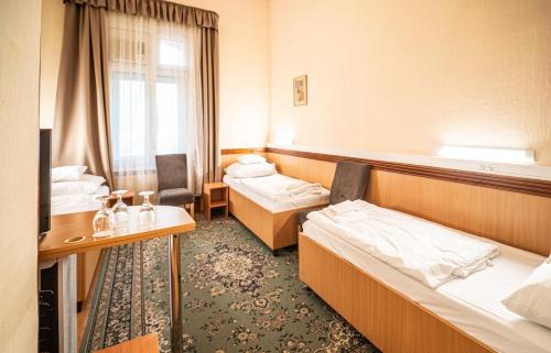a hotel room with two beds and a window at Tisza Hotel in Szeged