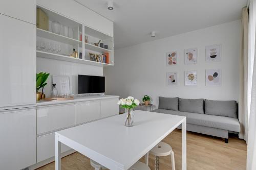 a white living room with a white table and a couch at APARTAMENT BLISKO TRÓJMIASTA I KASZUB, 20 minut komunikacją miejską do centrum Gdyni in Rumia