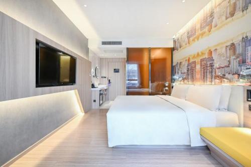 a bedroom with a white bed and a television at Atour Light Hotel Beijing West Station Maliandao in Beijing