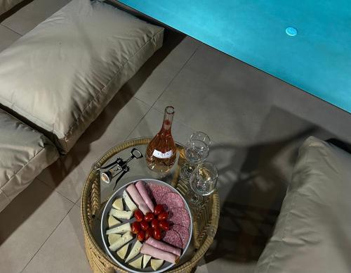 a table with a plate of food and a bottle of wine at XTC Villas Kefalonia - Villa X in Argostoli