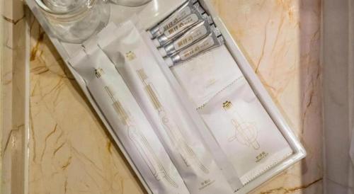 ein weißer Umschlag auf einem Tisch in der Unterkunft Metropolo Hotel Suzhou Guogou Plaza Huaxia in Suzhou