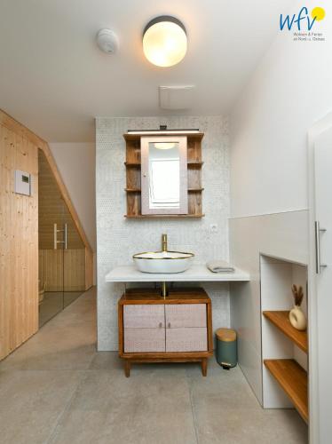 a bathroom with a sink and a mirror at Haus Casper Ferienwohnung 4 in Langeoog