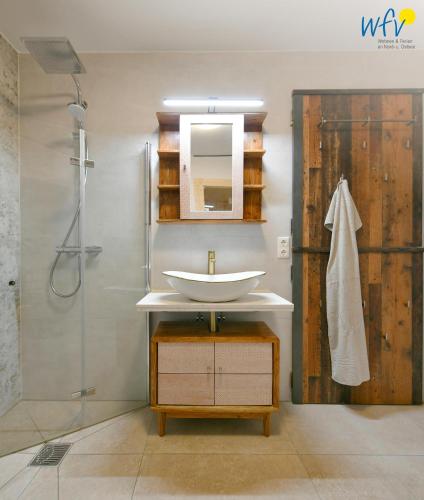 a bathroom with a sink and a shower at Haus Casper Ferienwohnung 3 in Langeoog