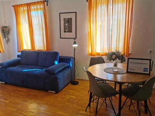 a living room with a blue couch and a table at Istrian old town apartment in Koper
