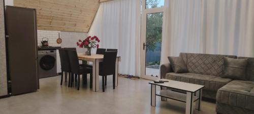 a living room with a couch and a table with chairs at A frame Qəçrəş in Qǝçrǝş